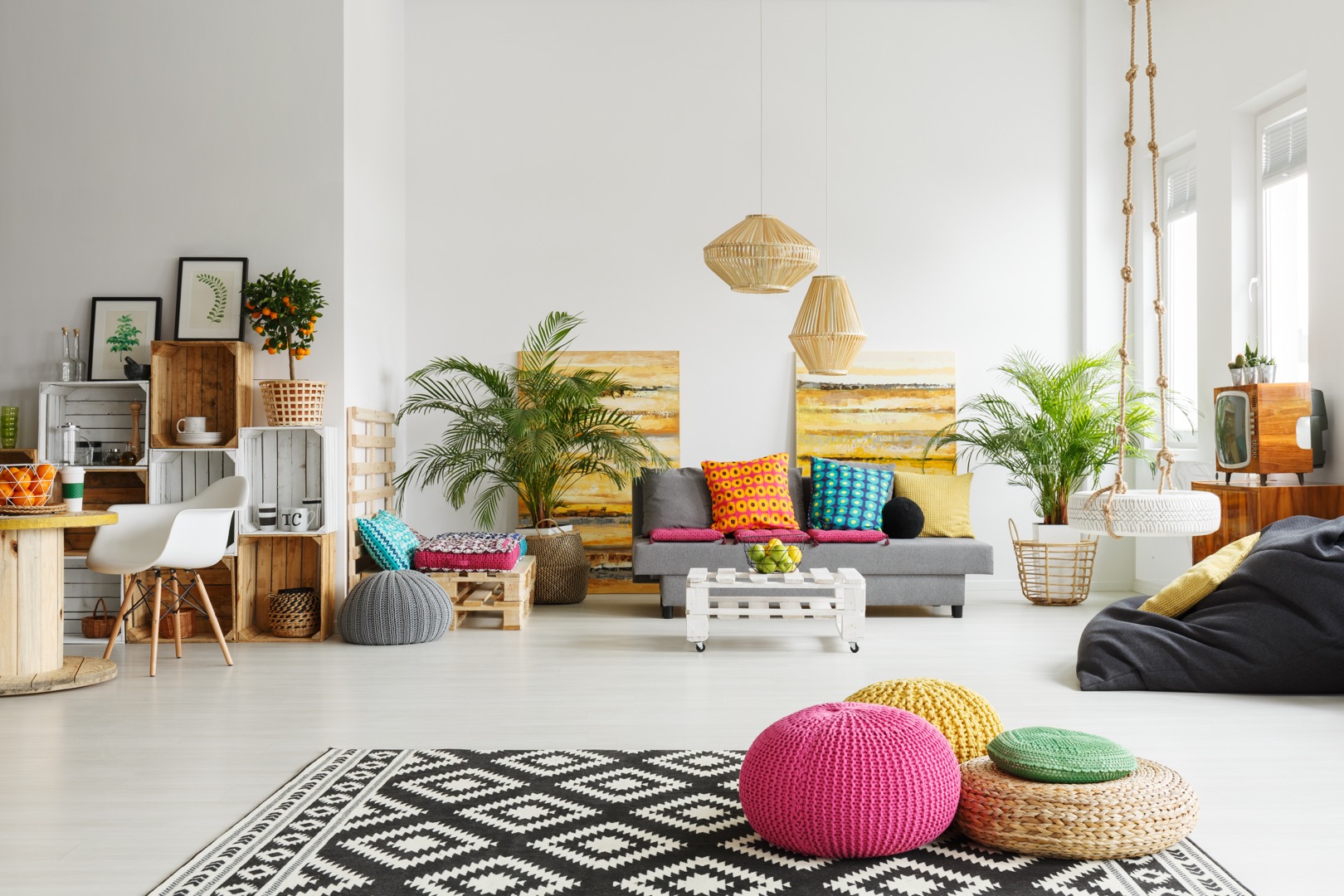 Loft living room with colorful poufs, sofa, carpet, crate furniture